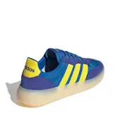 Championes urbanos Adidas modelo Barreda Decode, con diseño inspirado en el calzado de fútbol retro. Presentan una combinación de colores azul y violeta con las icónicas tres tiras en amarillo. Cuentan con puntera en forma de T, refuerzos de gamuza y una suela de goma translúcida.