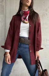 Sobrecamisa de pana color bordó, con cuello camisero, cierre frontal de botones y mangas largas con puños. Presenta una textura acanalada característica de la pana.