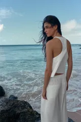 Pantalón ancho confeccionado en hilatura con lino, color blanco, de tiro alto con detalle de pinzas y lazada en la cintura.