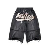 Short baggy de color negro con diseño desgastado, decorado con apliques de pedrería multicolor a lo largo de las costuras laterales y en el ruedo. Presenta un parche frontal bordado con la palabra 'Valley' y cordón ajustable en la cintura.