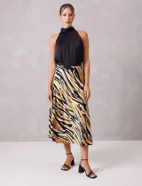 Falda midi de satén con estampado tribal en tonos negro, beige y mostaza. Presenta un corte fluido y cintura elastizada para mayor comodidad.