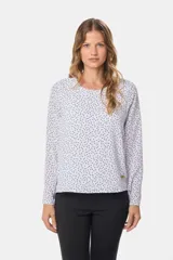Blusa blanca con estampado de lunares negros, de manga larga y cuello redondo con abertura en la espalda.