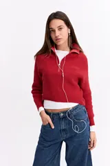 Buzo de tejido de punto con trama marcada, color rojo, diseño de cuello alto con cierre frontal y mangas largas.