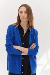 Cárdigan azul eléctrico de punto liviano con botones al frente y bolsillos delanteros.