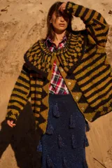 Saco de punto con diseño geométrico y rayas horizontales, cuello amplio y botones artesanales. Presenta una combinación de colores chocolate y beige.