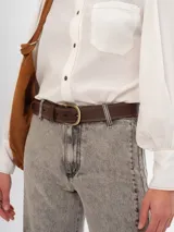 Cinturón marrón de cuero con costuras a contratono y hebilla dorada.