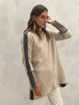 Sweater de punto color beige con patrón de espiga, cuello alto, mangas largas con franjas grises y puños acanalados.