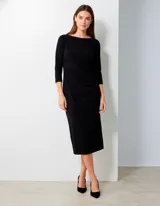Vestido negro de seda fría, corte midi, con escote barco y mangas tres cuartos. Presenta frunces drapeados en la zona de la cintura y cadera.
