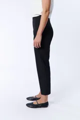 Pantalón de vestir negro, corte carrot con botón y cierre frontal.