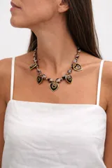 Collar de cuentas de resina con efecto carey, adornado con dijes en forma de corazón con borde dorado y centro oscuro.