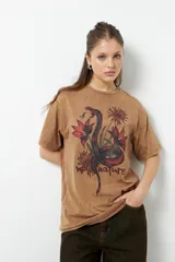 Remerón color marrón con estampa de una serpiente y flores.