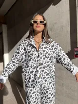 Camisa de denim con estampado de manchas de vaca, corte recto y cierre frontal con botones.