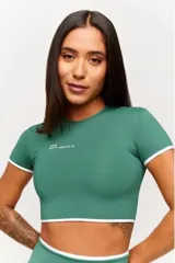 Conjunto deportivo compuesto por top cropped y calza larga tiro alto, color verde oscuro con detalles en blanco.