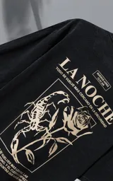 Remera de algodón premium con efecto nevado, corte oversize y cuello redondo. Presenta una estampa gráfica en la espalda con motivos de escorpión, rosa y tipografía en color crema.