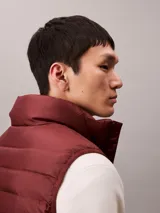 Chaleco acolchado tipo puffer Calvin Klein, con cuello alto y cierre frontal con cremallera. Diseño sin mangas confeccionado en nailon reprocesado.