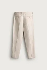 Pantalón de traje regular fit de lino color verde militar, con bolsillos laterales y bolsillos traseros de doble vivo con botón. Cierre frontal con cremallera y botón.