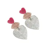 Par de aros colgantes con forma de corazón cubiertos de glitter plateado, con pieza superior de labios color nude y corazón fucsia.