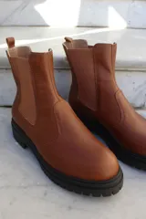 Bota tipo chelsea de cuero color chocolate, con paneles laterales elásticos y suela track de goma negra.
