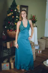 Vestido largo con estampado tie-dye en tonos violeta y fucsia, escote en V con detalles bordados dorados, cut-outs laterales bajo el busto y tirantes finos que se cruzan y atan en la espalda.