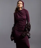 Vestido midi color bordó, de manga larga y corte ajustado, con diseño de cuello alto y fruncidos laterales. Presenta detalles de pliegues asimétricos en el hombro.