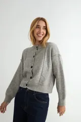 Cardigan de punto color marrón chocolate, con cuello redondo, cierre frontal de botones y diseño de costuras verticales visibles. Presenta puños y ruedo acanalados.