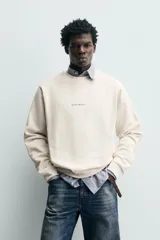 Sudadera de corte regular fit confeccionada en tejido de algodón con interior afelpado. Presenta cuello redondo, manga larga, acabados en rib y estampado de texto a contraste en el frente.