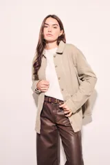 Sobrecamisa color beige de algodón peinado, corte recto, con cuello camisero, cierre frontal con botones y bolsillos de parche en el pecho.