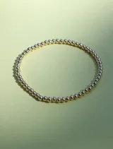 Pulsera elástica de cuentas de 3mm en oro laminado 14 kilates.