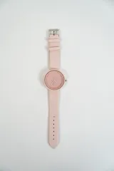 Reloj de pulsera color naranja con correa de cuero sintético, esfera redonda con números y agujas del mismo color.