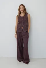 Pantalon de corte recto y pierna ancha, confeccionado en tejido con textura tipo espiga en tono bordó oscuro. Presenta costuras a la vista en contraste y bolsillos laterales.