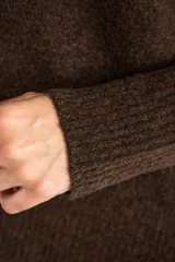 Sweater de tejido de punto color bordó, con cuello redondo, mangas largas y puños acanalados. Presenta un diseño de corte recto y textura suave.