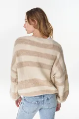 Cardigan tejido de punto a rayas horizontales en tonos crudo y beige, de manga larga y diseño holgado.