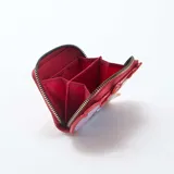 Monedero rojo con diseño temático de Stitch de Disney, decorado con apliques de árboles de Navidad y cierre perimetral con tirador metálico.