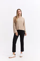 Remera de manga larga color beige con silueta relajada y mangas amplias. Presenta una estampa en la espalda con la frase 'Be kind to your mind' acompañada de ilustraciones de un cupido, flores y lazos en tono bordó.