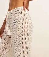 Pantalón de playa tejido al crochet color blanco, con cintura elastizada con lazo y borlas.