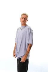 Remerón de corte oversize color lila, con mangas cortas caídas y cuello redondo. Presenta estampados en el frente y en la espalda.