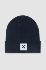 Gorro tipo beanie de punto en color azul marino, con vuelta y parche rectangular blanco con el logo de la marca en el frente.