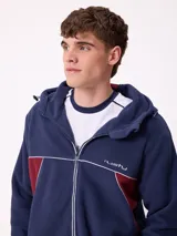 Campera de polar con cierre frontal, capucha ajustable y diseño con bloques de color azul marino y detalles en bordó. Presenta el logo de la marca bordado en el pecho.