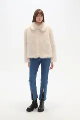 Campera de piel sintética color negro, con cuello, manga larga y cierre frontal. Presenta un diseño de corte holgado y textura suave.