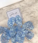 Aros colgantes de gran tamaño con diseño floral, elaborados en resina con efecto marmolado en color celeste.