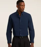Camisa de hombre de corte regular, confeccionada en tejido oxford de algodón azul marino, con cuello tradicional abotonado y mangas largas.