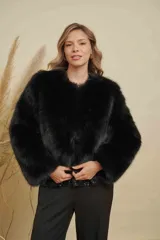 Abrigo corto de piel sintética en tono beige, con cuello redondo y mangas largas. Diseño de corte recto y textura suave.