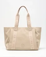 Cartera tote color taupe de símil cuero con tiras de hombro estampadas con la marca y detalle de logo circular en el frente.