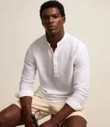 Camisa de manga larga con cuello tipo padre y cierre frontal parcial con botones. Confeccionada en una mezcla de lino y algodón, presenta un corte amplio y cómodo.