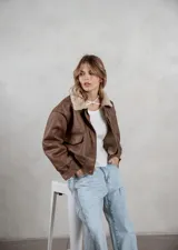 Campera de ecocuero color marrón, con forro interno de corderito sintético, cuello clásico, cierre frontal y bolsillos laterales.