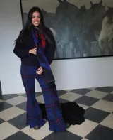 Pantalón de lana a cuadros color beige y blanco, entallado hasta la rodilla y con caída amplia tipo oxford, tajos laterales, elástico en la cintura y cierre oculto.