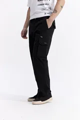 Pantalón cargo de corte baggy, color beige, con bolsillos laterales tipo cargo con cierre y solapa, y diseño de pierna ancha.