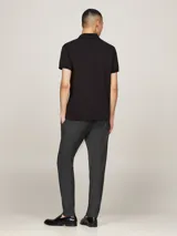 Chomba negra Tommy Hilfiger Sport de corte regular, confeccionada en tejido técnico de piqué de mezcla de algodón elástico, con tecnología Flex, que absorbe la humedad y es antiolor. Tiene cuello de chomba, cartera de dos botones, logo de Tommy Hilfiger Sport en el pecho y detalles distintivos de la marca.