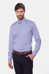 Camisa de manga larga con cuello abotonado y estampa a cuadros en tonos de azul y blanco. Presenta un bolsillo aplicado en el pecho con detalle de bordado y cierre frontal con botones.