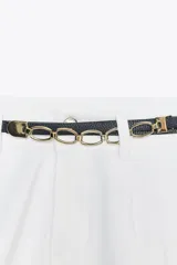 Shorts blancos de tiro alto con pinzas delanteras y bolsillos laterales. Incluye un cinturón fino negro con hebilla de cadena dorada.